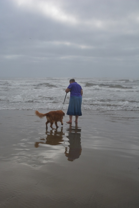 a lady and her dog on the beach